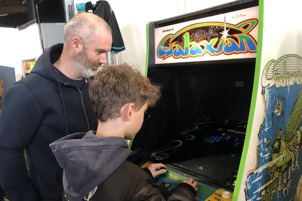 Alexandre fait découvrir les bornes d'arcade à son fils Simon, dans un des stands de la Gamers Assembly de Poitiers.