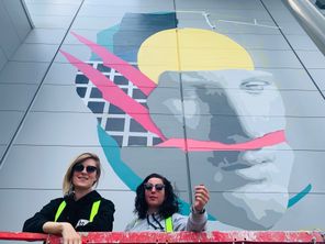 Les artistes rémoises Mat et Zekky, en haut de leur nacelle face à leur fresque en Seine-et-Marne. 