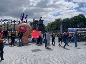 Une vingtaine de personnes syndiquées se rassemble en musique devant le siège des champagnes Pommery à Reims. 